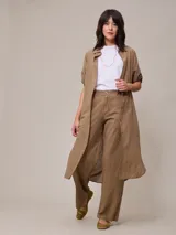 Pantalón de lino color tostado, de corte recto y tiro alto, con trabillas para cinto y bolsillos laterales.
