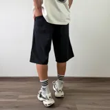 Bermuda de jean corte baggy en color gris oscuro con efecto deslavado, diseño amplio y bolsillos laterales.