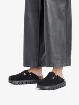 Sandalias cerradas de gamuza negra con plantilla anatómica de corcho-látex y suela de goma con plataforma. Presentan una tira ancha ajustable con hebilla metálica.