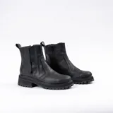 Bota corta tipo chelsea de cuero vacuno color marrón, con suela track de goma negra y elástico lateral.