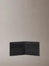 Billetera plegada Calvin Klein de cuero con textura granulada, cuenta con ocho ranuras para tarjetas y compartimento interior para billetes, con logo de la marca grabado en la parte frontal.