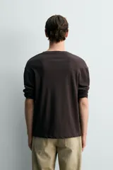Camiseta relaxed fit de manga larga y cuello redondo, confeccionada en tejido de mezcla de algodón y lino, en color negro.