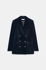 Blazer de pana azul marino con diseño cruzado, cuello solapa, hombreras marcadas y cierre frontal con botones. Cuenta con bolsillos delanteros con solapa y abertura en la espalda.