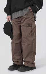 Pantalón cargo marrón de calce regular, confeccionado en textil técnico pesado. Posee cintura con cordón ajustable, bolsillos cargo de gran tamaño en los laterales y puños ajustables con tancas en los tobillos.