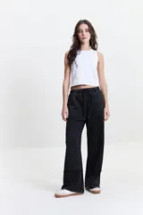 Pantalón de felpa negro con cintura elastizada ajustable, bolsillos laterales y corte acampanado.