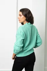 Buzo de tejido de punto con diseño de ochos, cuello redondo y mangas largas con puños acanalados.