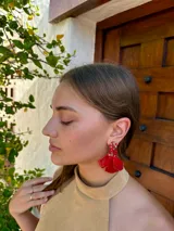 Caravanas colgantes de diseño floral en color rojo intenso, compuestas por una base de cuentas pequeñas y pétalos de resina en forma de flor.