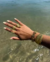 Pulsera de diseño artesanal elaborada eslabón por eslabón a mano, con eslabones circulares texturados de metal dorado y cadena regulable.