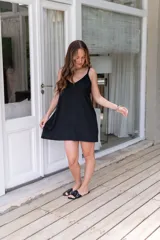 Vestido corto negro de muselina con breteles finos y escote en V.