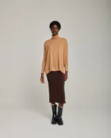 Sweater tipo poncho color beige, de mangas largas con sisa caída y cuello alto.