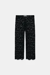 Leggings capri negros confeccionados en tejido de encaje, con tiro alto, cintura elástica y bajo acabado en ondas.