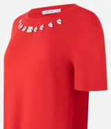 Blusa blanca de mangas cortas confeccionada en viscosa con cuello redondo con brillos en formas florales.