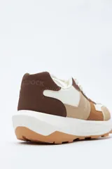 Zapatilla urbana de diseño contemporáneo con capellada que combina paneles de diferentes texturas en color negro, ajuste con cordones y suela robusta de color blanco.