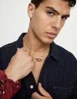 Collar largo dorado con cadena de eslabones rectangulares y cierre de mosquetón entrelazado.