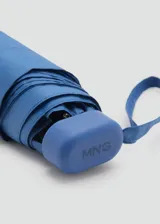 Paraguas plegable de tamaño mini en color azul, con funda a juego y correa de mano integrada.