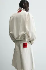 Bermuda de denim color crudo o blanco roto, de corte ancho (baggy fit) y largo hasta la rodilla. Presenta cinco bolsillos, bordado a tono en el frente y un parche con logo en la parte trasera.