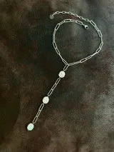 Corbatín con cadena de acero quirúrgico color plateado y perlas de río. Se puede usar ajustado al cuello o más suelto. Se cierra con ganchito para regular el largo.