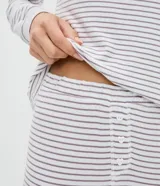 Conjunto de pijama de dos piezas compuesto por una blusa de manga larga con cuello redondo y un pantalón largo con cintura elástica. Ambas prendas presentan un diseño de rayas horizontales finas.