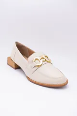 Mocasines de cuero en tono bronce metalizado, con detalle de aplique metálico dorado en el empeine y taco cuadrado bajo de madera.