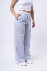 Pantalon de corte amplio y tiro bajo, confeccionado en tela de franela con estampado de cuadros en tonos blanco, negro y gris. Cuenta con cintura elástica con cordón ajustable y bolsillos laterales.