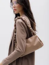 Blazer sastre de mujer color beige, con diseño abierto sin cierre frontal, mangas largas y solapas clásicas.