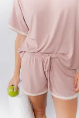 Pijama de algodón compuesto por una remera de cuello redondo y mangas cortas con detalle de puntilla, y un short con cintura elástica y ruedo con puntilla.