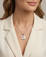Collar de cadena fina de plata 925 con dije circular de nácar y diseño central de trébol de cuatro hojas con incrustaciones de circonias.