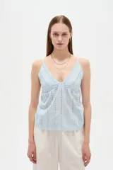 Musculosa blanca de algodón con diseño de broderie, escote en V, tirantes finos regulables y corte holgado.