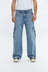 Pantalón de jean celeste con corte amplio, bolsillos laterales tipo cargo y tiro medio.