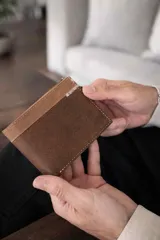 Billetera de cuero marrón con diseño combinado de dos texturas y detalle de costura decorativa en zigzag en la parte superior. Cuenta con compartimentos internos para billetes, tarjetas y visor.