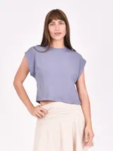 Remera corta de algodón color crema, con cuello redondo y mangas cortas caídas.