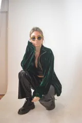 Campera verde inglés de terciopelo con cierre dorado y cuello alto.