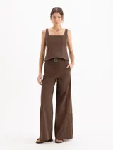 Pantalon Sun de tiro medio-alto y silueta wide leg, color marron. Posee elastic en la espalda, cinto con hebilla, tajos en las botamangas y pinzas traseras.