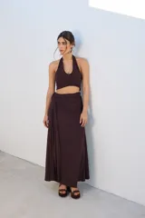 Falda larga de tejido brillante color azul con detalle de nudo en la cintura.