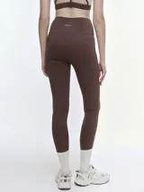 Calza deportiva de tiro alto en color violeta, confeccionada en tejido técnico elástico de alta compresión, con costuras reforzadas y diseño ajustado al cuerpo.