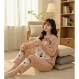 Conjunto de pijama de dos piezas confeccionado en tela de plush suave y abrigada. Incluye una remera de manga larga con diseño estampado de Totoro y pantalón largo a juego con puños en contraste.