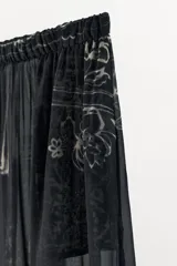Pantalón bombacho de tiro medio, confeccionado en tejido semitransparente de viscosa con estampado floral. Presenta cintura elástica, bolsillos laterales y bajo abullonado con acabado elástico.