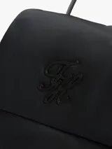 Mochila de diseño moderno y funcional Tommy Hilfiger, color negro, confeccionada en poliéster reciclado. Cuenta con asa superior, correas ajustables, cierre con solapa y el logo monograma de la marca bordado en el frente.