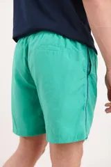 Short de baño verde con cintura elástica y cordón ajustable.