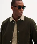 Campera bomber masculina de terciopelo cotelé color beige, con cuello redondo, mangas largas, cierre frontal de botones forrados, bolsillos laterales y terminaciones de elástico en puños y cintura.