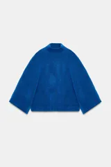 Jersey de punto liso en color azul vibrante, con cuello subido y mangas anchas de diseño acampanado. Presenta acabados en rib en el cuello y los puños.