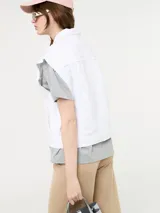 Chaleco blanco de jean con botones metálicos y sisas desflecadas.