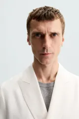 Blazer color crudo de lino y algodón, corte regular, con cuello de solapa de pico, manga larga con puños abotonados, bolsillos de vivo en el pecho y bolsillos de solapa en la cadera, bolsillo interior, aberturas en la espalda y cierre frontal cruzado con botones.