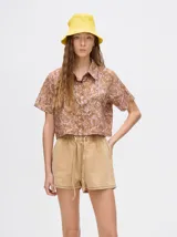 Short de denim color camel con cintura elástica ajustable mediante cordón. Presenta un corte relajado y un pequeño bordado de sol amarillo en el bolsillo trasero derecho.