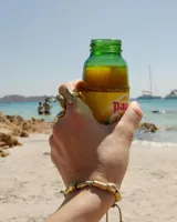 Anillo de diseño orgánico y macizo con forma irregular, elaborado en metal con acabado brillante. Presenta una estructura abierta que permite su ajuste.