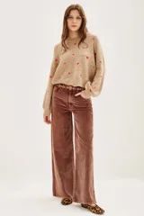 Pantalón de pana marrón, de corte wide leg, con tiro medio y bolsillos delanteros y traseros.