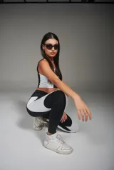 Calza deportiva larga negra con recortes laterales blancos.