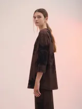 Remera marrón con estampado abstracto en negro, de corte holgado y mangas 3/4.