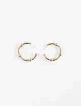 Aros tipo argolla de acero quirúrgico hipoalergénico color dorado, con bolitas decorativas.