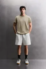 Pantalones cortos tipo jogger de corte relajado confeccionados en tejido de algodón. Presentan cintura elástica con cordón interior, bolsillos frontales en la cadera y un bolsillo trasero de plastrón.